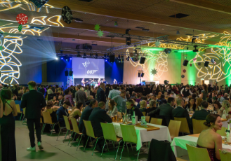 Festsaal gefüllt mit vielen Menschen, Blick auf die Bühne